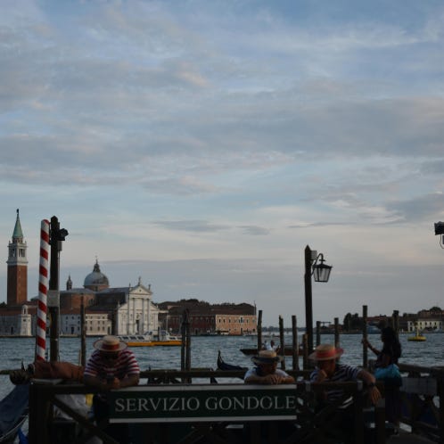 Photo of Gondoliers Waiting by a Canal